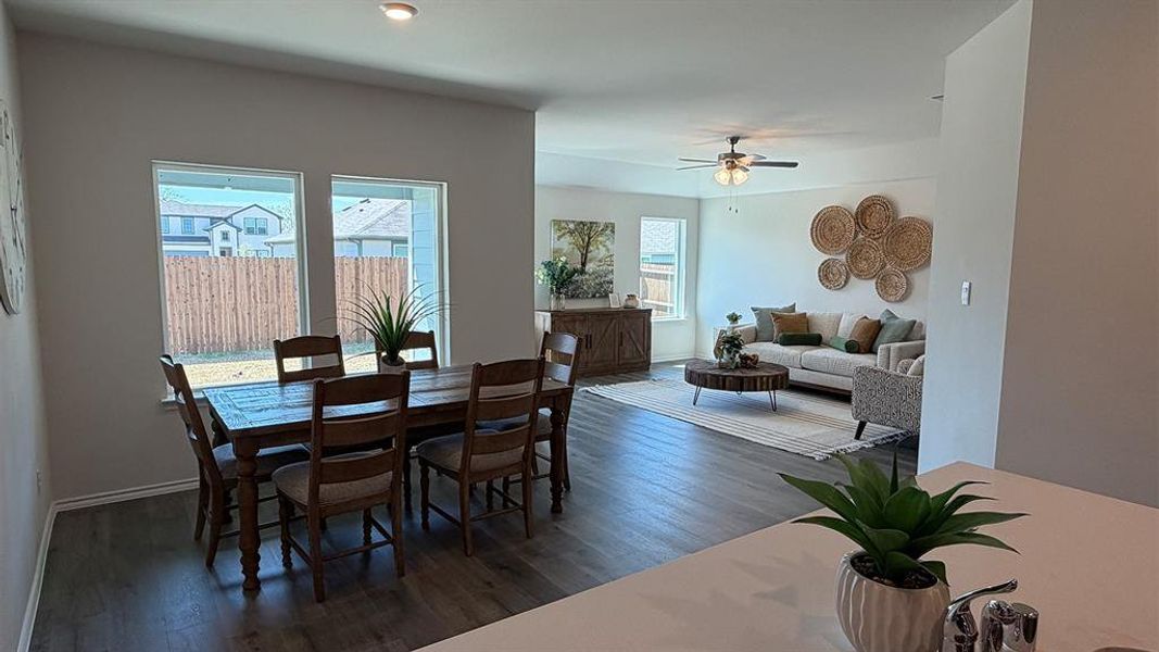Dining space with dark wood-style floors and ceiling fan
