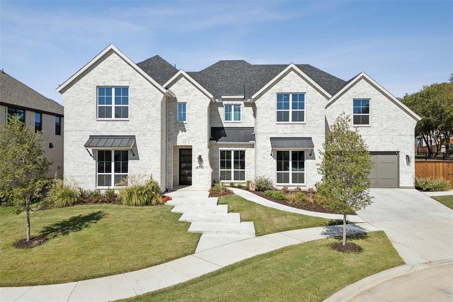 View of front of house featuring a front yard and a garage