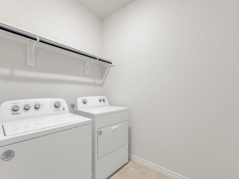 Laundry room with washer and dryer and light tile patterned floors