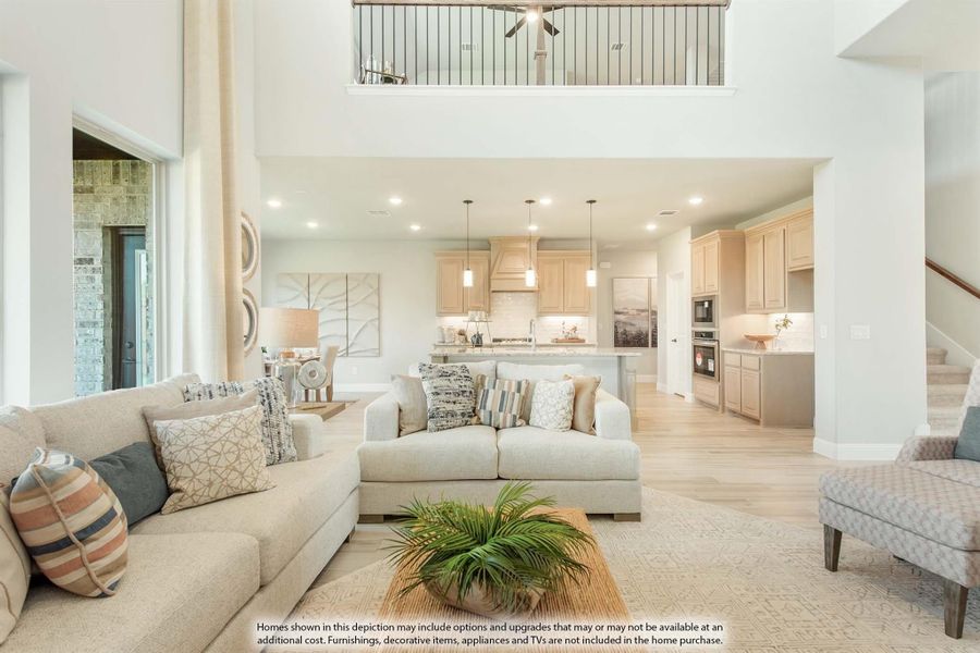Open-concept living room with two-story ceiling, neutral sofas, and kitchen visible in background Open-concept living room with two-story ceiling, neutral sofas, and kitchen visible in background