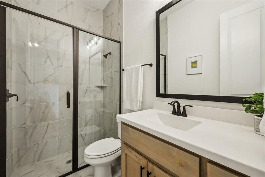 Bathroom featuring vanity, a shower stall, and toilet