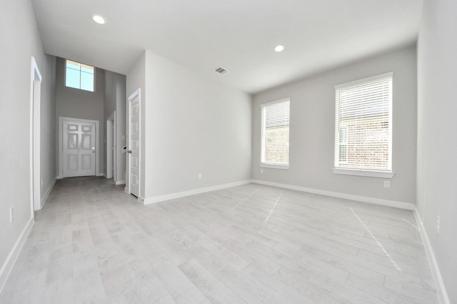 Create lasting memories with your family and friends at the dining table! This expansive dining room showcases sophisticated flooring, custom paint, and seamlessly connects to the family room and kitchen, providing an open and inviting atmosphere. Sample photo of completed home with similar floor plan. Actual colors and selections may vary.