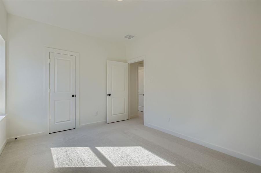 Unfurnished bedroom with light colored carpet and a closet Unfurnished bedroom with light colored carpet and a closet