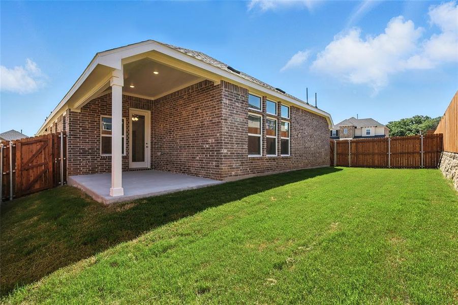 Rear view of house with a patio, brick siding, and a fenced backyard Rear view of house with a patio, brick siding, and a fenced backyard