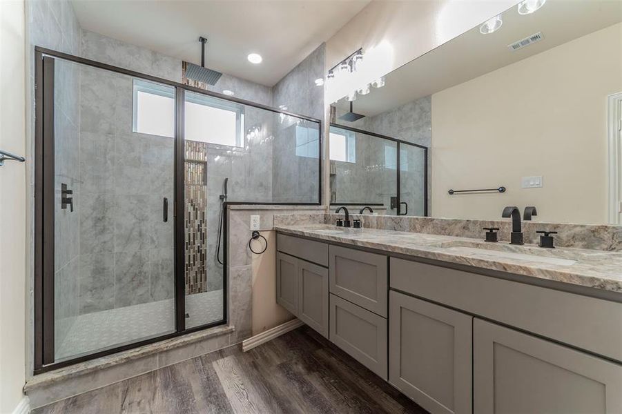 Bathroom featuring vanity, hardwood / wood-style floors, and a shower with shower door