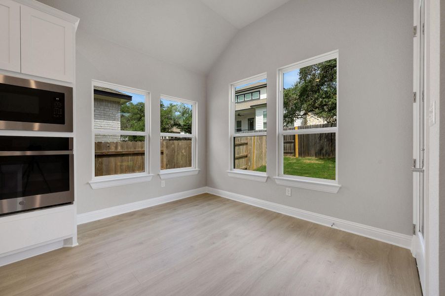 Unfurnished sunroom featuring plenty of natural light and vaulted ceiling