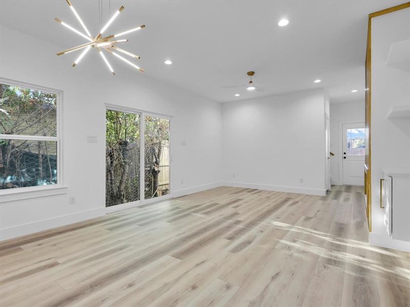 Unfurnished room with light hardwood / wood-style flooring and ceiling fan with notable chandelier