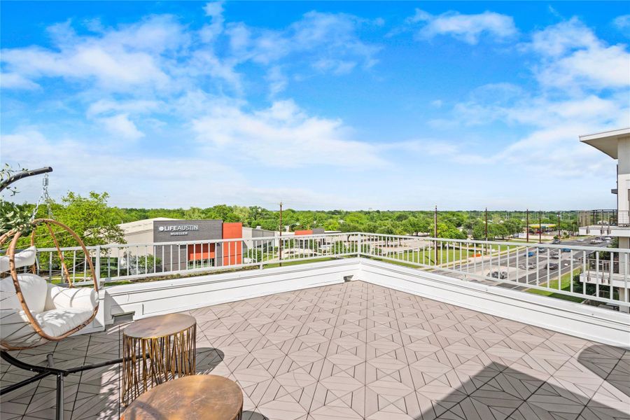 Expansive rooftop terrace featuring patterned tile flooring and white perimeter railing