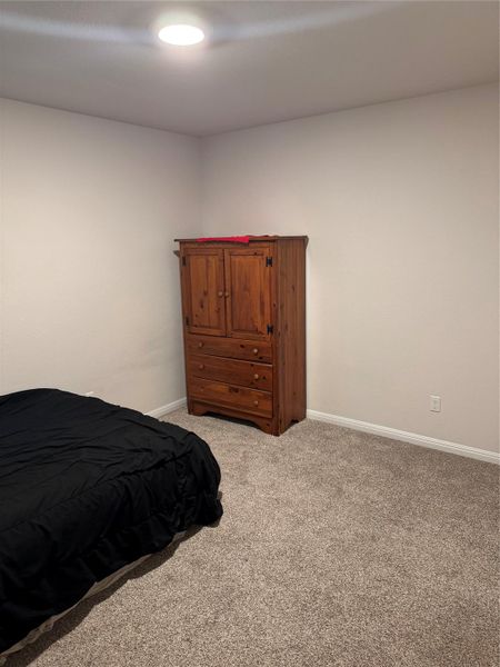 Bedroom with light colored carpet and baseboards