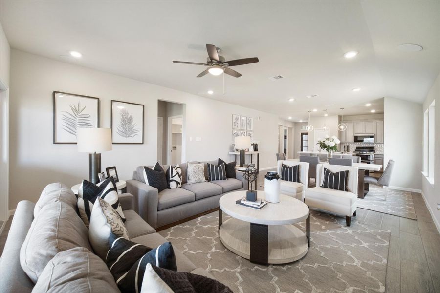 Gather the family and guests together in your lovely living room! Featuring soaring high ceilings, recessed lighting, ceiling fan, custom paint, gorgeous floors, and large windows that provide plenty of natural lighting throughout the day. Sample photo of completed home with similar floor plan. Actual colors and selections may vary.