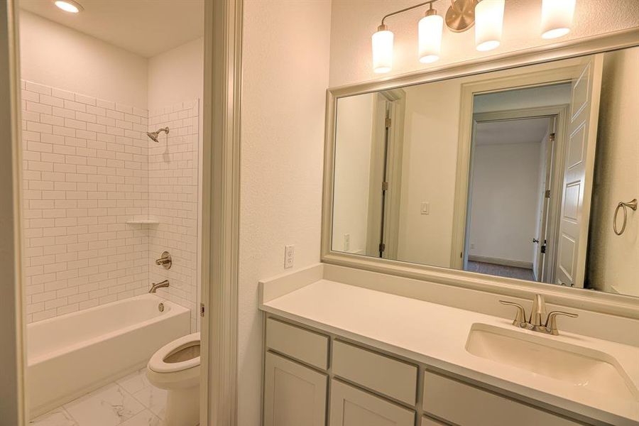 Full bath with tub / shower combination, vanity, and a textured wall Full bath with tub / shower combination, vanity, and a textured wall