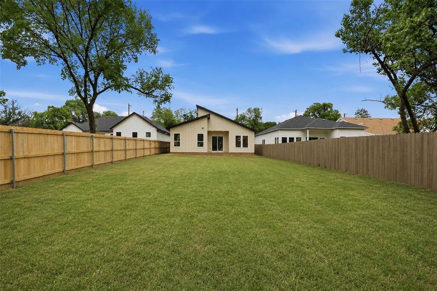 Expansive green lawn with a newly installed wood privacy fence