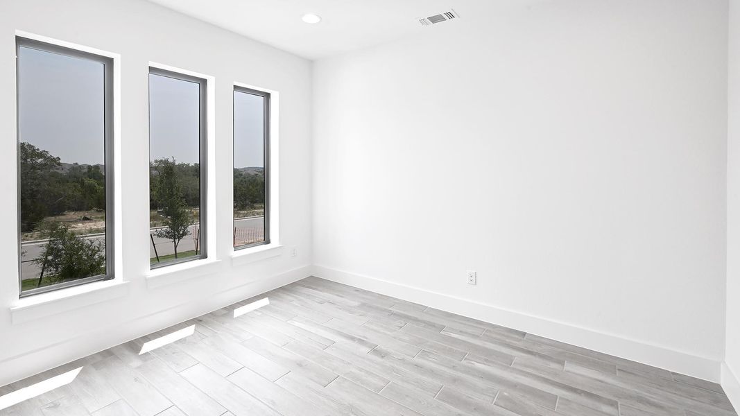 Empty room with light wood-style floors, baseboards, and recessed lighting Empty room with light wood-style floors, baseboards, and recessed lighting