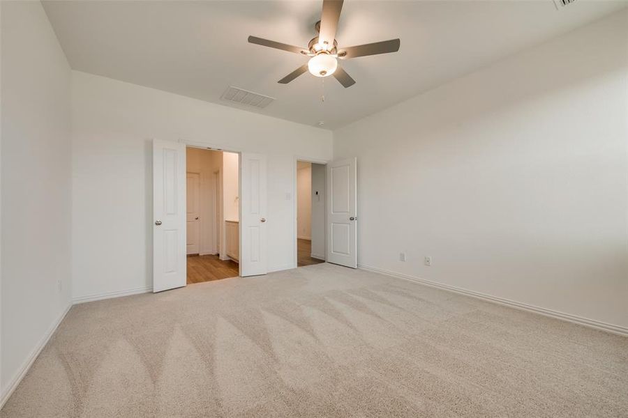 Unfurnished bedroom featuring light carpet and ceiling fan