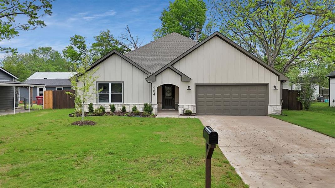 View of front of property featuring roof with shingles, concrete driveway, fence, a garage, and board and batten siding View of front of property featuring roof with shingles, concrete driveway, fence, a garage, and board and batten siding