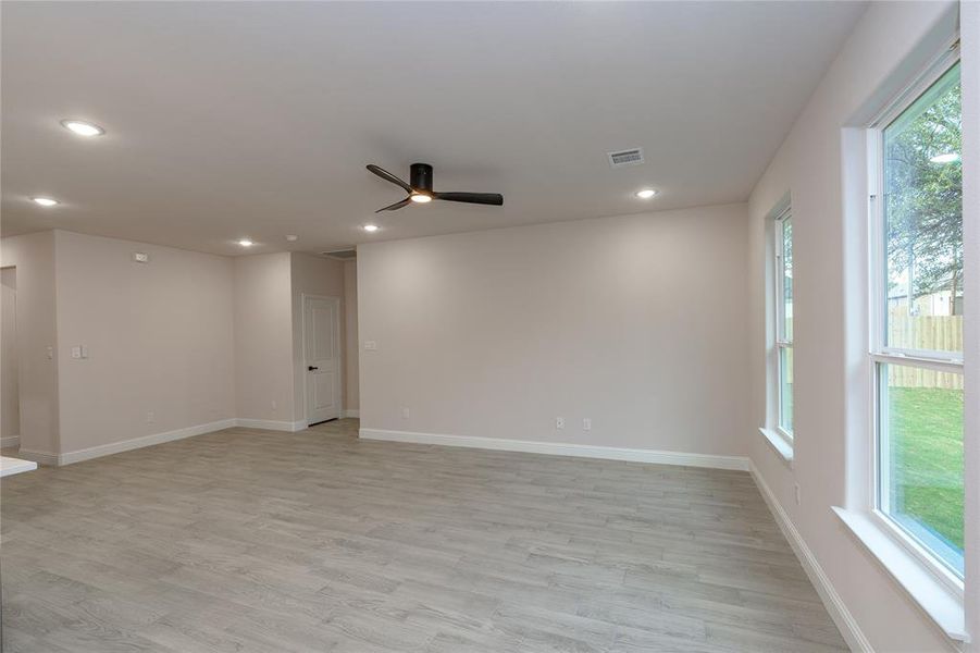 Living room featuring ceiling fan, plenty of natural light, and light hardwood / wood-style flooring