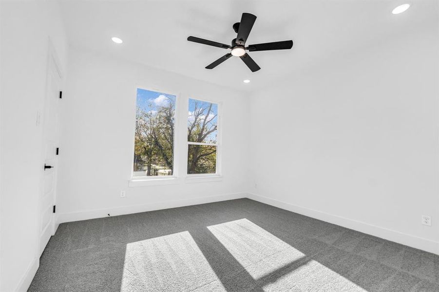 Carpeted empty room with ceiling fan