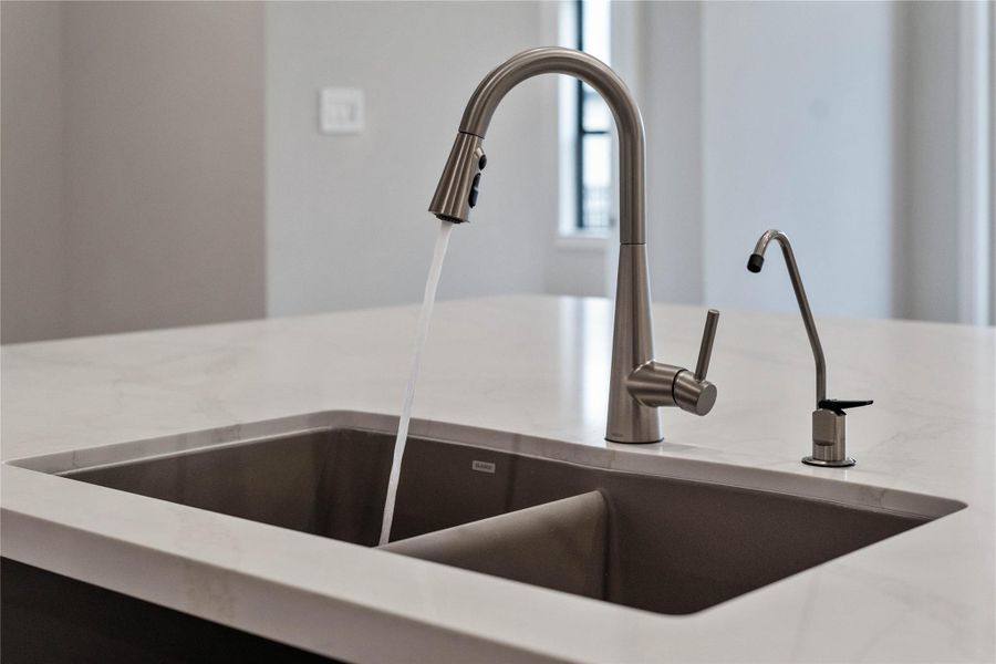 The Moen Sleek stainless steel kitchen faucet offers versatility and contemporary design, complemented by a convenient separate filtered water dispenser faucet.