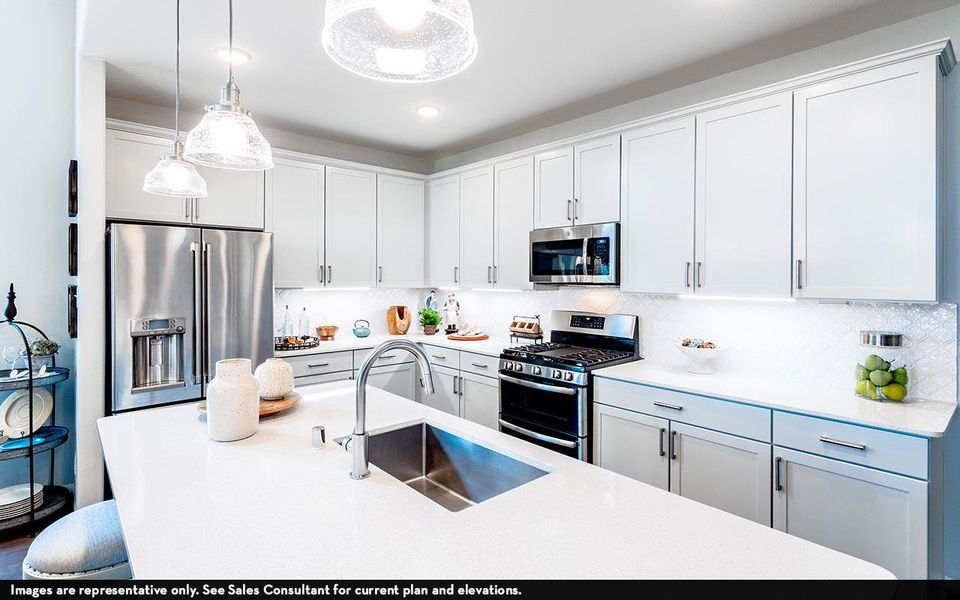 Kitchen featuring stainless steel appliances, a sink, pendant lighting, light countertops, and decorative backsplash Kitchen featuring stainless steel appliances, a sink, pendant lighting, light countertops, and decorative backsplash