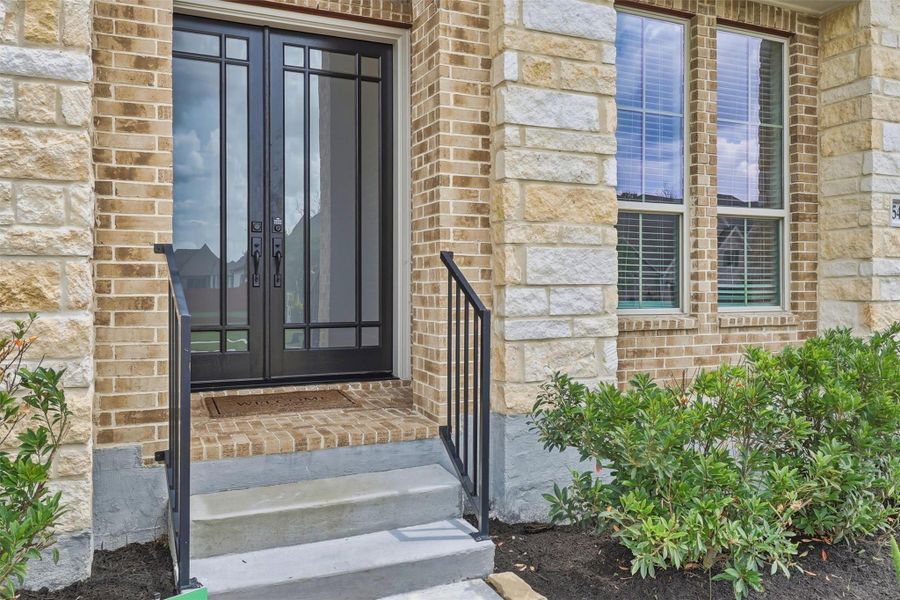 Brick and stone front elevation with stunning double door entrance.