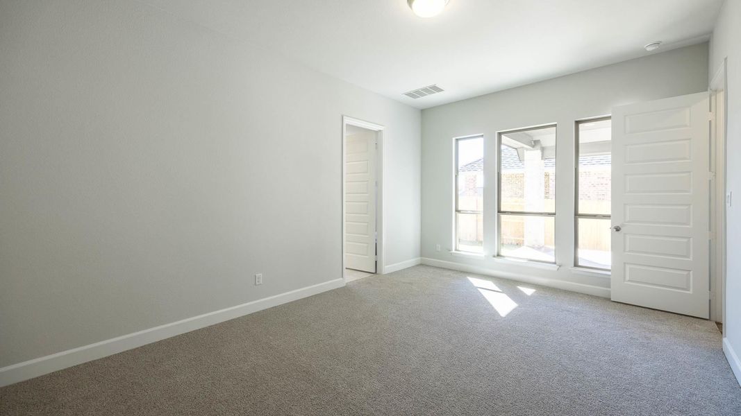 Unfurnished room featuring light carpet, visible vents, and baseboards