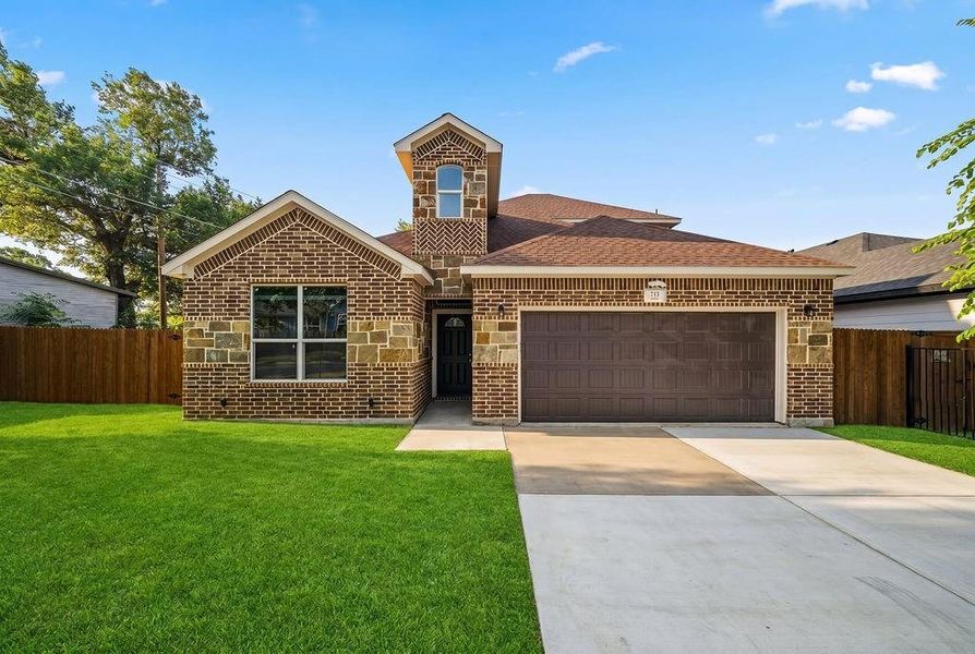 Brick and stone veneer exterior featuring a two-car garage, concrete driveway, and a wood privacy fence Brick and stone veneer exterior featuring a two-car garage, concrete driveway, and a wood privacy fence