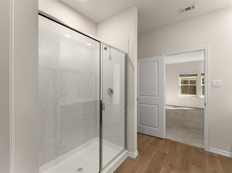 Bathroom featuring hardwood / wood-style flooring and a shower with door