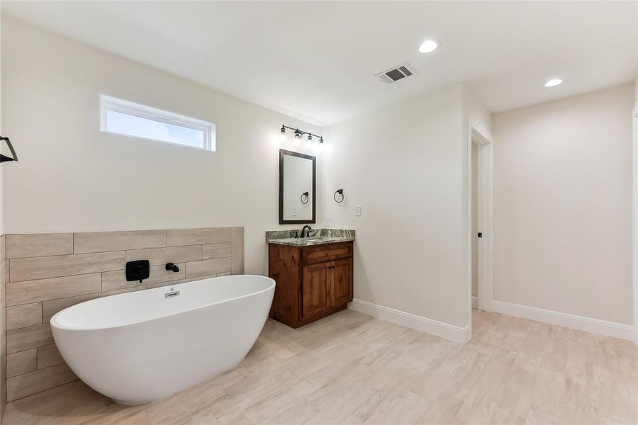 Full bathroom featuring vanity, a freestanding tub, baseboards, visible vents, and recessed lighting Full bathroom featuring vanity, a freestanding tub, baseboards, visible vents, and recessed lighting