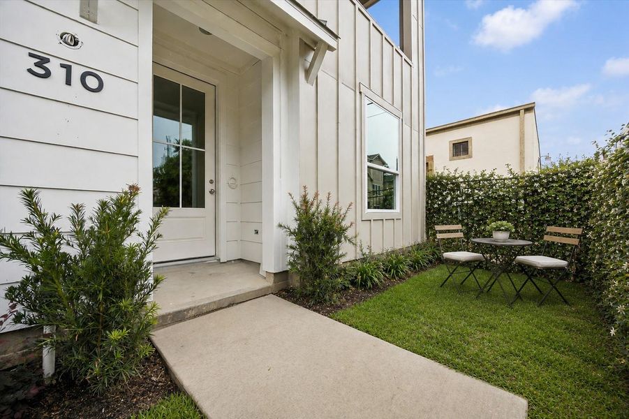 Charming fenced front yard with plenty of green space and welcoming curb appeal. Mature fence ivy digitally enhanced.