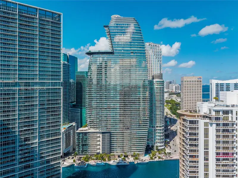 High-rise glass facade building featuring a curved architectural profile, multiple cantilevered terraces, and deep-water boat slips High-rise glass facade building featuring a curved architectural profile, multiple cantilevered terraces, and deep-water boat slips