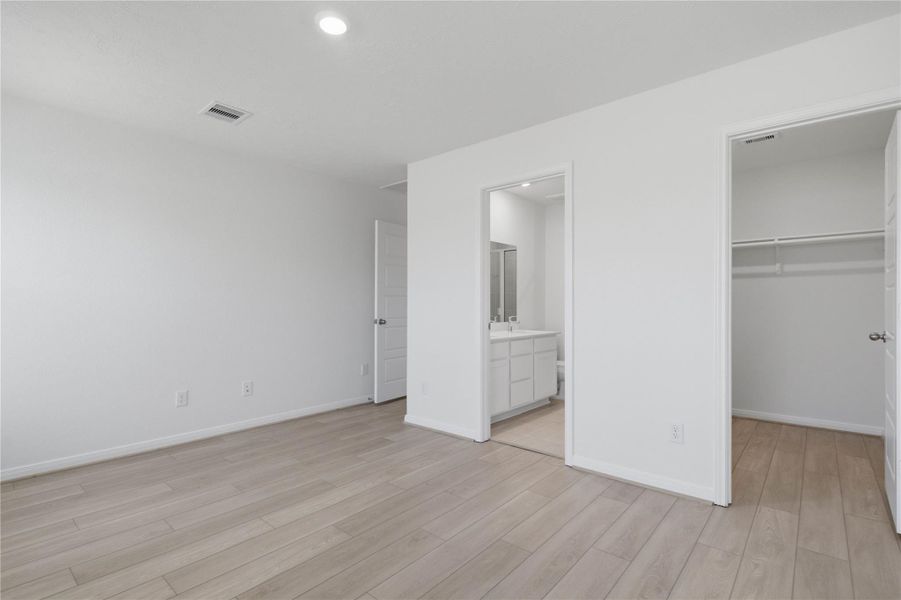 The primary suite's walk-in closet and ensuite bathroom.