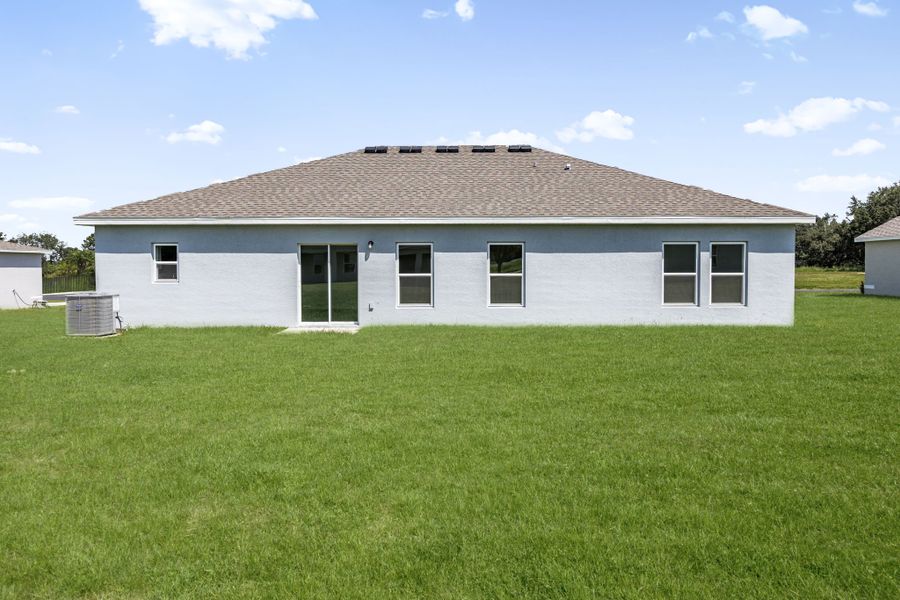 A white house with a grass yard.