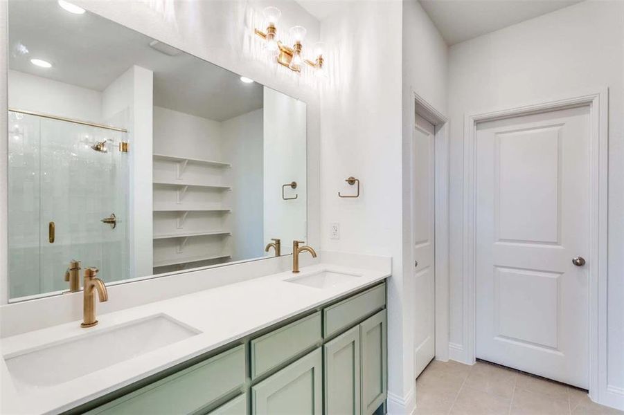 Bathroom with a stall shower, double vanity, and tile patterned floors Bathroom with a stall shower, double vanity, and tile patterned floors