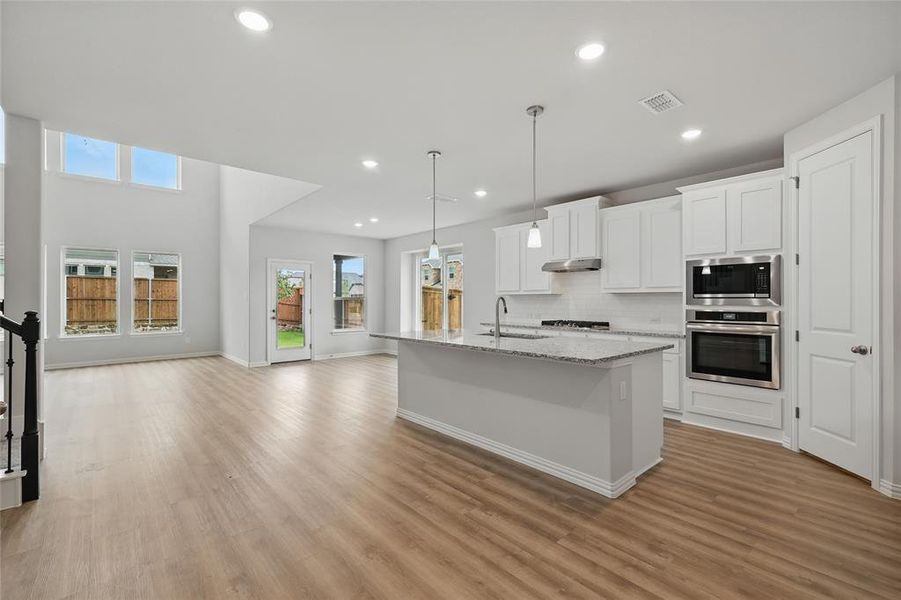 Kitchen with stainless steel appliances, a sink, healthy amount of natural light, light wood-type flooring, and recessed lighting Kitchen with stainless steel appliances, a sink, healthy amount of natural light, light wood-type flooring, and recessed lighting