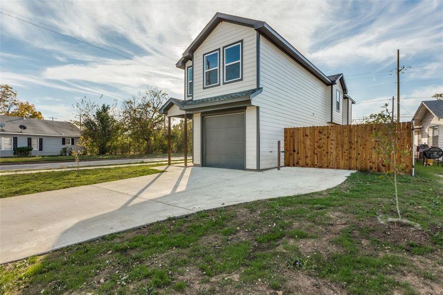 View of side of property with a lawn and a garage