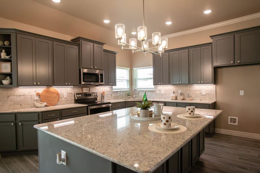 Kitchen with open shelves, stainless steel appliances, light stone countertops, a center island, and recessed lighting Kitchen with open shelves, stainless steel appliances, light stone countertops, a center island, and recessed lighting