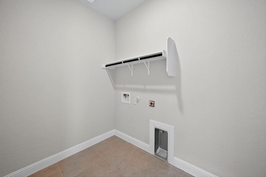 Washroom with hookup for a gas dryer, light tile patterned floors, and washer hookup Washroom with hookup for a gas dryer, light tile patterned floors, and washer hookup