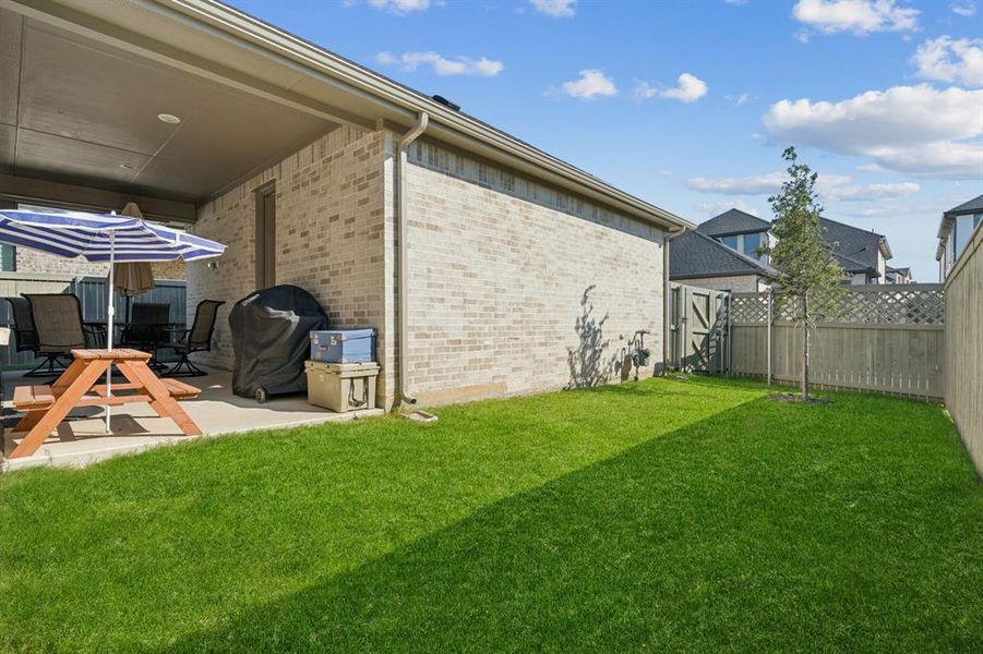 Fenced backyard with a patio area Fenced backyard with a patio area