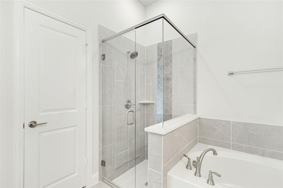 Bathroom with glass-enclosed tile shower and soaking tub with silver fixtures Bathroom with glass-enclosed tile shower and soaking tub with silver fixtures