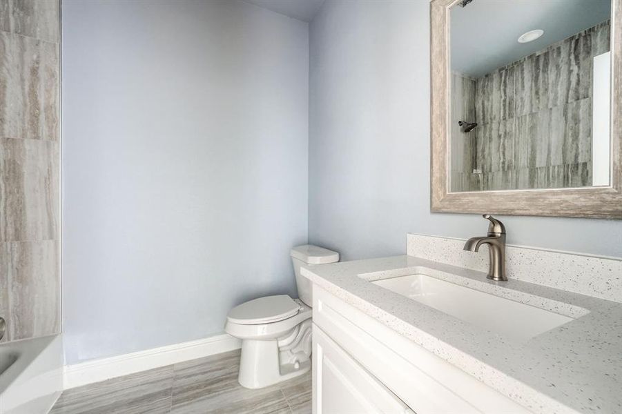 Full bathroom featuring tile patterned floors, toilet, vanity, and shower / bathtub combination