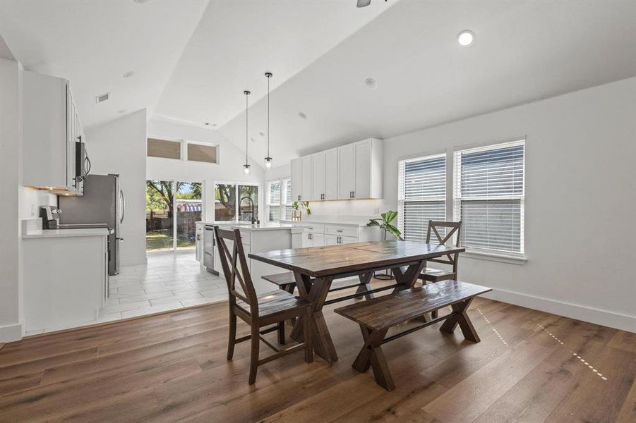 Dining space featuring light wood-style floors and high vaulted ceiling