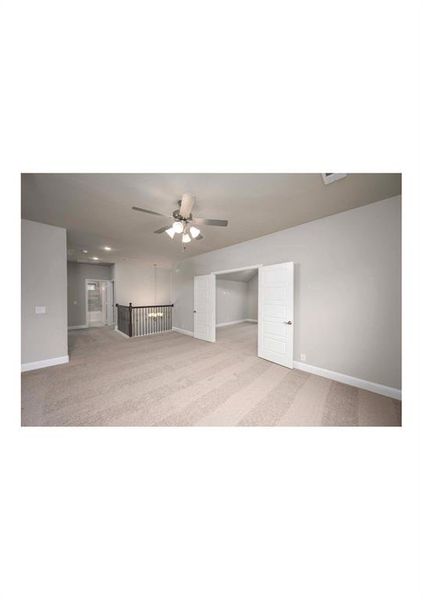 Unfurnished living room featuring light colored carpet and ceiling fan