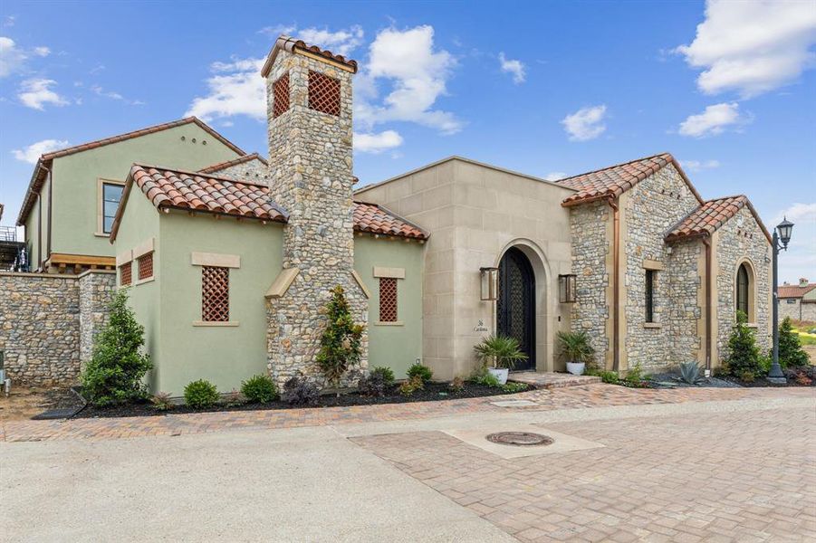 Mediterranean / spanish-style home with a tiled roof, stucco siding, a chimney, and stone siding Mediterranean / spanish-style home with a tiled roof, stucco siding, a chimney, and stone siding