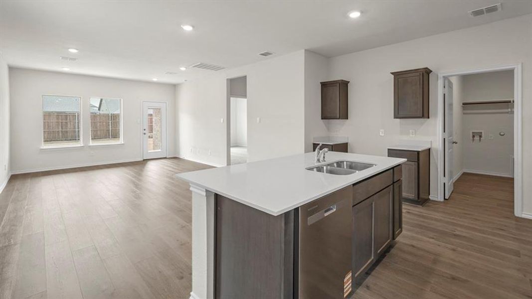 Open-concept living space featuring wood-finish flooring, recessed lighting, and white walls