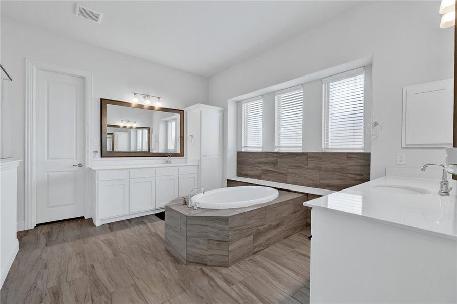 Bathroom with two vanities and a garden tub
