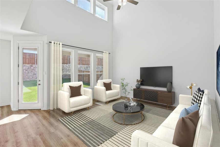 Living room featuring light hardwood / wood-style flooring, a high ceiling, and ceiling fan