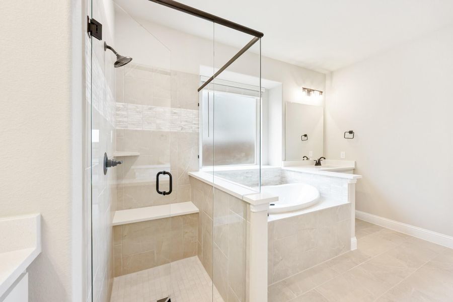 Bathroom with glass-enclosed walk-in shower, soaking tub, and beige tile floors