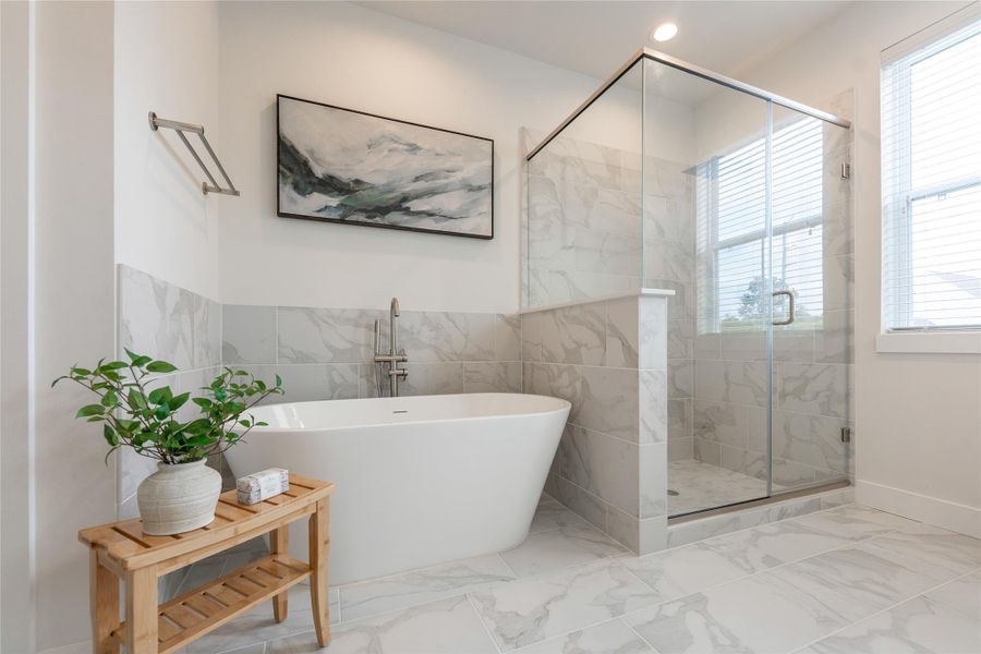 A luxurious soaking tub and sleek glass-enclosed shower, perfect for relaxation and style.