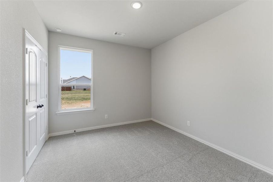 Empty room featuring light carpet and baseboards