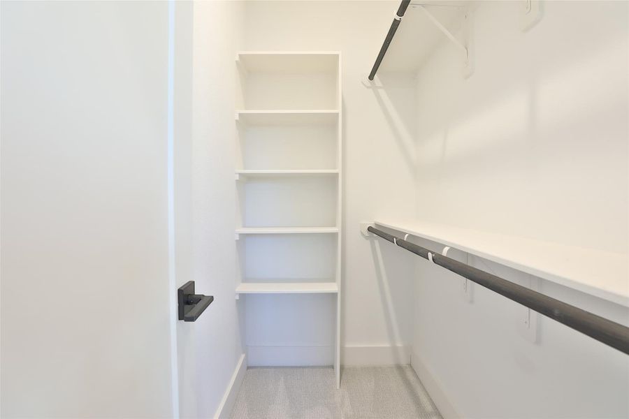 A spacious primary walk-in closet with plenty of room for shoes, accessories, and more. A spacious primary walk-in closet with plenty of room for shoes, accessories, and more.